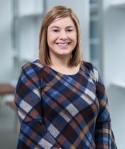 smiling woman wearing a plaid striped dress