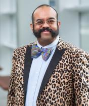 smiling man with glasses and leopard print suit