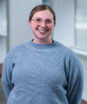 smiling woman with glasses and blue sweater