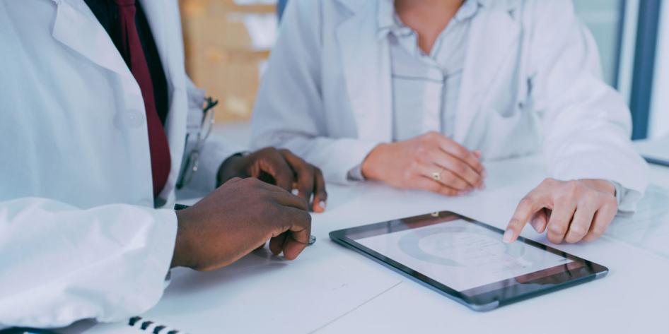 Two people with their hands touching a screen
