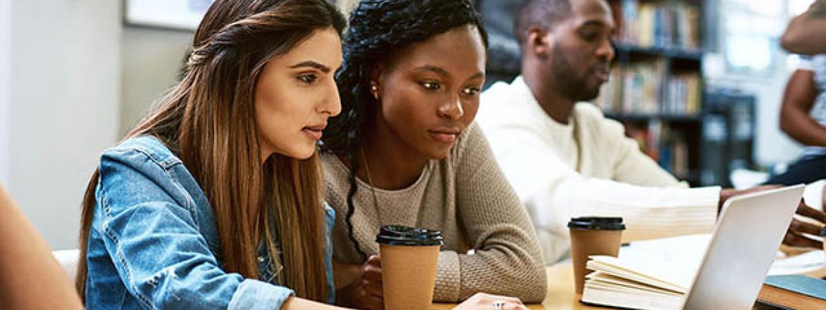 Two female students working on a laptop