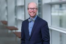smiling man in glasses and dark suit