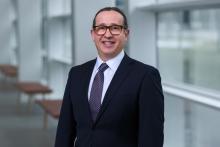 smiling man in glasses and dark suit
