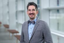 smiling man with dark hair and glasses