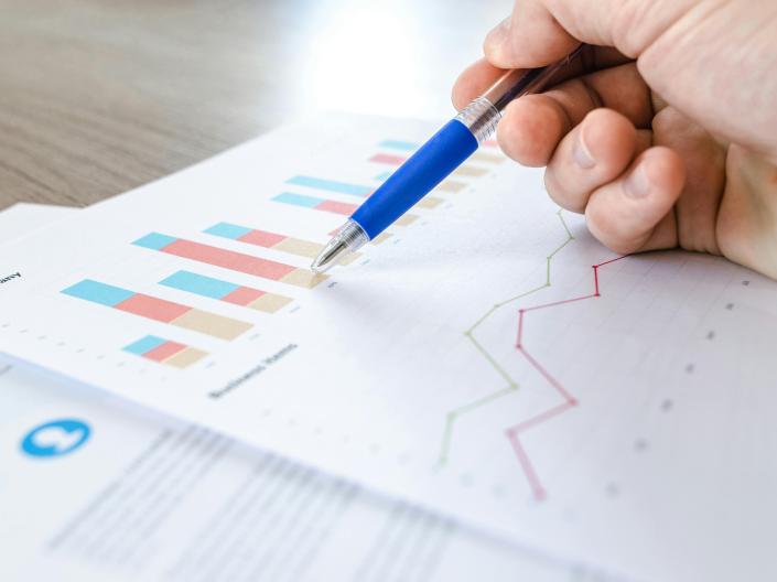 Pen pointing at data analytics paper.
