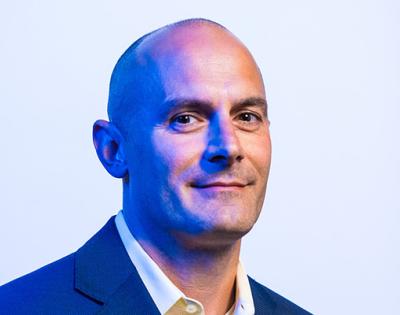 A photographic portrait of Jeff Capadona in blue suit