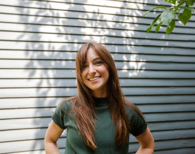 A photograph of Marissa Scavuzzo outside standing in front of siding on a house.