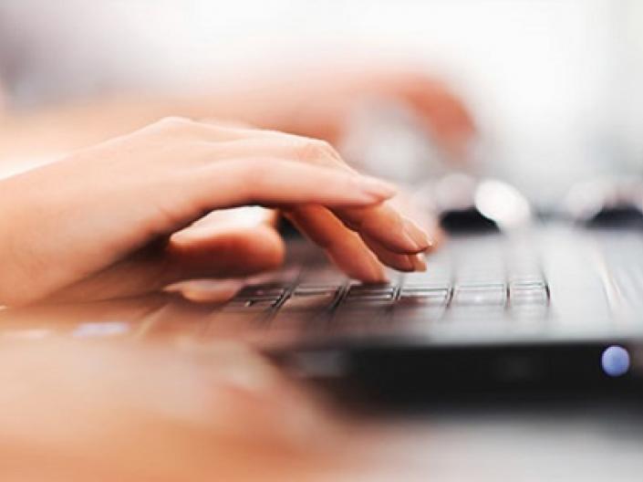 A lady working on a laptop.