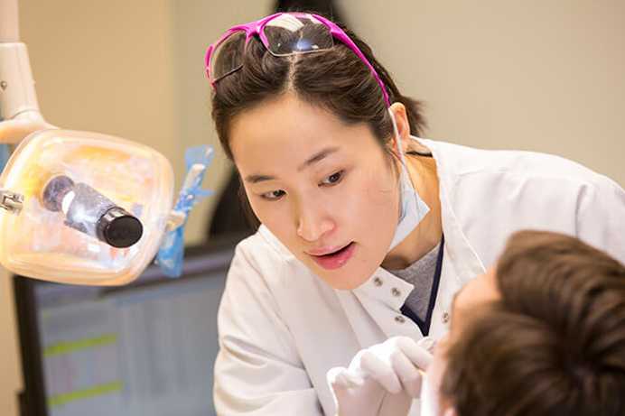 Photo of a Case Western Reserve University dental student looking in a patient’s mouth