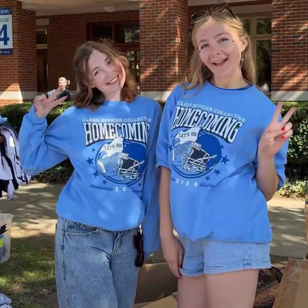 Two students pose in the 2025 homecoming merch.