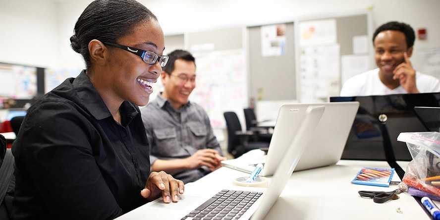 students smiling with a laptop