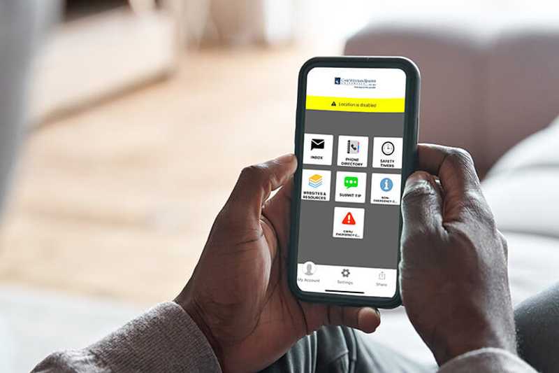 Photo of a person’s hands holding a smartphone with the Rave Guardian app open