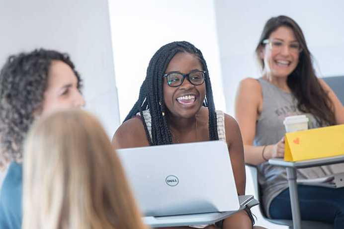 Photo of a group of Case Western Reserve University students sitting in a Mandel School classroom, smiling