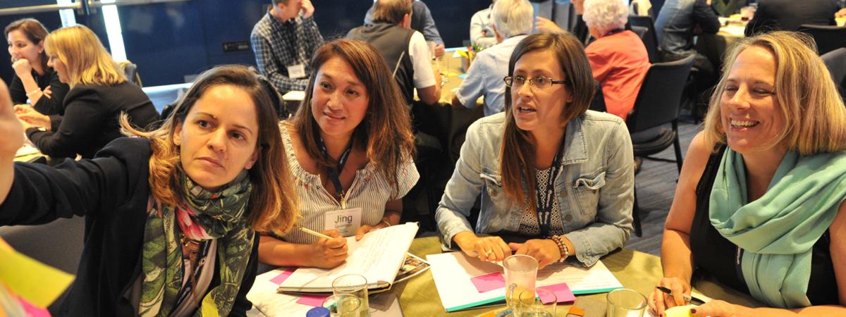 4 women working together at global forum