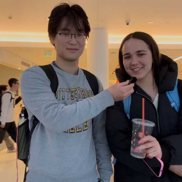 Two students sharing a mini microphone in Tinkham Veale University Center.
